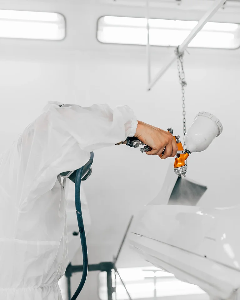 Person lackiert ein Auto als Beispiel für die Nutzung von CO₂-basierten Rohstoffen in Beschichtungen und Lacken.